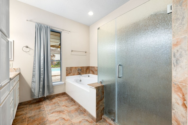 bathroom featuring vanity, a textured ceiling, and independent shower and bath