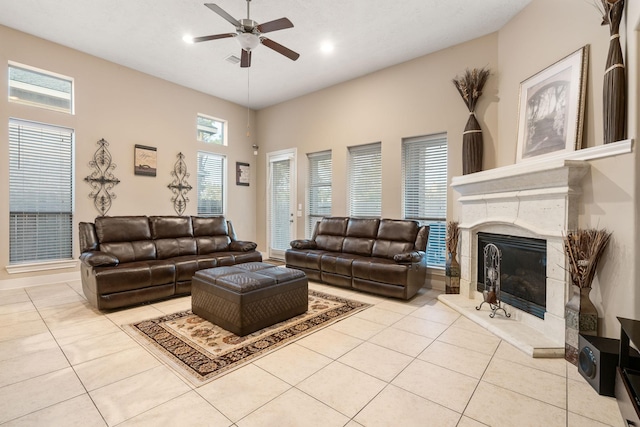 living room featuring ceiling fan, light tile patterned floors, and a high end fireplace