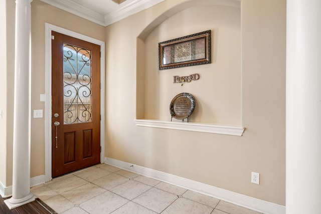 tiled foyer entrance featuring decorative columns and ornamental molding