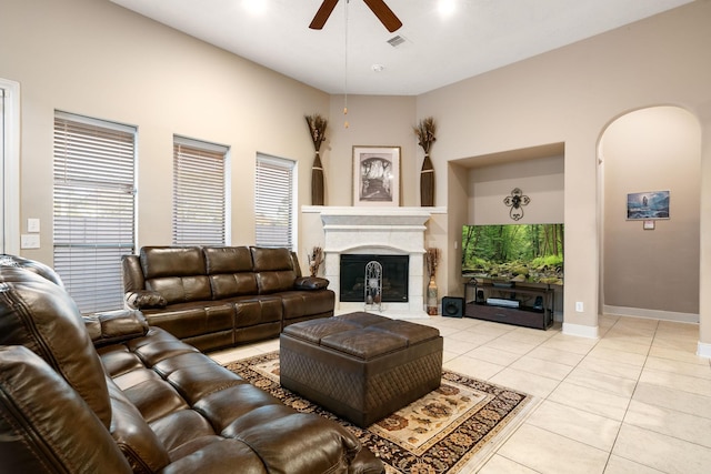 tiled living room with a fireplace and ceiling fan