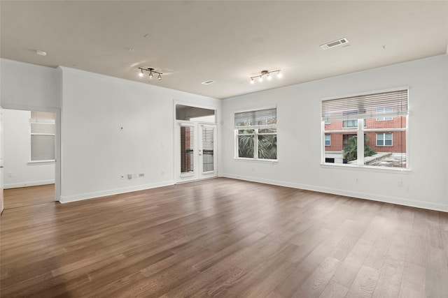 empty room featuring hardwood / wood-style floors and track lighting