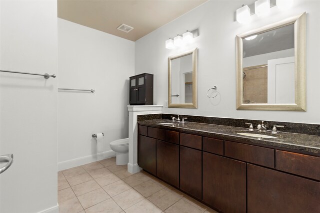 bathroom featuring tile patterned floors, vanity, and toilet