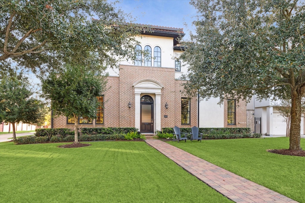 mediterranean / spanish home featuring a front lawn