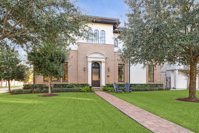 mediterranean / spanish home featuring a front lawn