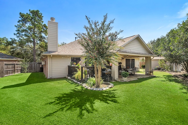 back of house featuring a lawn, ceiling fan, and a patio