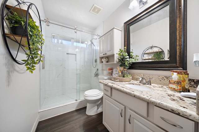 bathroom with vanity, hardwood / wood-style flooring, toilet, and walk in shower