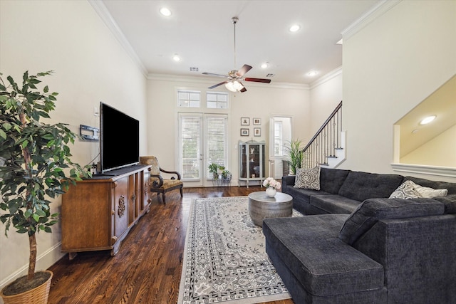 living room with ceiling fan, dark hardwood / wood-style flooring, crown molding, and a towering ceiling