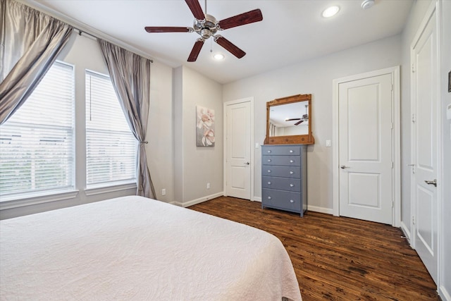 bedroom with ceiling fan, dark hardwood / wood-style flooring, and multiple windows