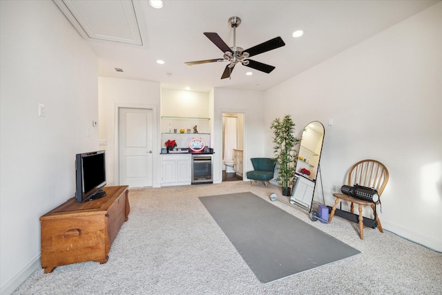 sitting room featuring ceiling fan, light colored carpet, and beverage cooler