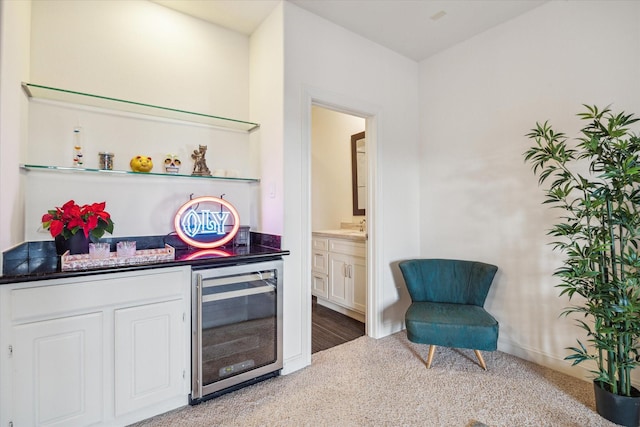 bar with carpet flooring, wine cooler, and white cabinets