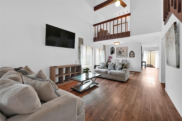 living room with a high ceiling, wood-type flooring, and ceiling fan