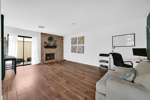 living room with a brick fireplace and wood-type flooring