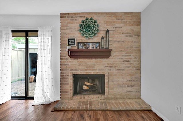 details with hardwood / wood-style floors and a brick fireplace