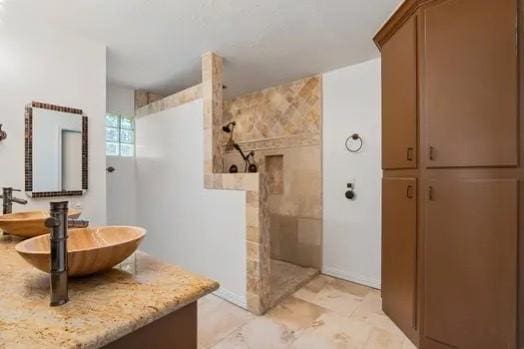 bathroom with vanity and tiled shower