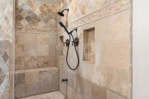 interior details featuring tiled shower