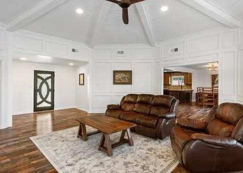 living room with ceiling fan, lofted ceiling with beams, and wood-type flooring