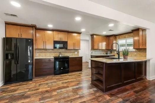 kitchen featuring backsplash, dark wood-type flooring, sink, and black appliances