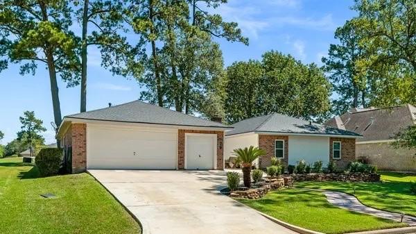 single story home featuring a front lawn and a garage