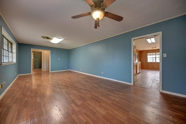 empty room featuring hardwood / wood-style floors, ceiling fan, and crown molding