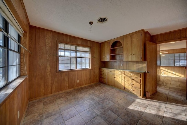 kitchen featuring wooden walls and a textured ceiling