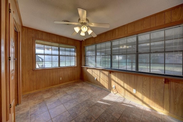 unfurnished sunroom featuring ceiling fan