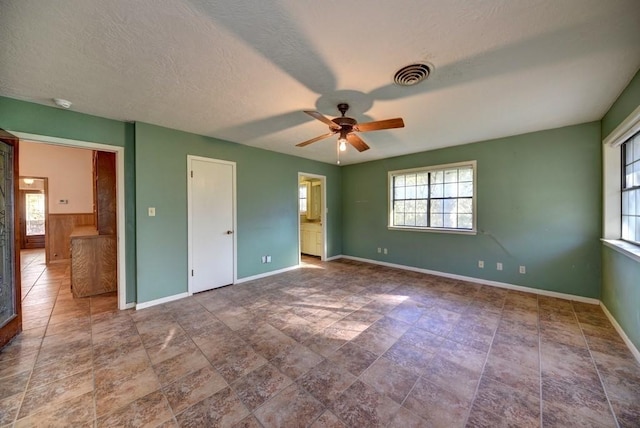 unfurnished bedroom featuring ceiling fan, a textured ceiling, and connected bathroom