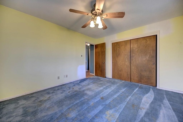 unfurnished bedroom featuring ceiling fan, a closet, and dark colored carpet