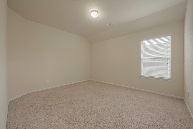 unfurnished room with carpet floors and lofted ceiling