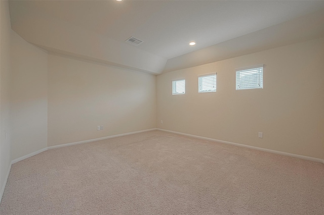 carpeted empty room featuring lofted ceiling