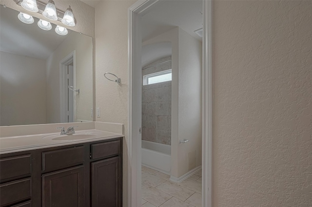 bathroom featuring tile patterned flooring, vanity, and  shower combination