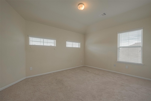 carpeted empty room with lofted ceiling