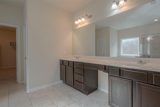 bathroom with tile patterned flooring, vanity, and walk in shower