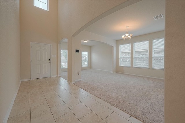 foyer entrance featuring light carpet and a notable chandelier