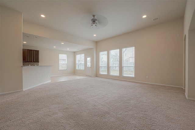 unfurnished living room with ceiling fan and light carpet