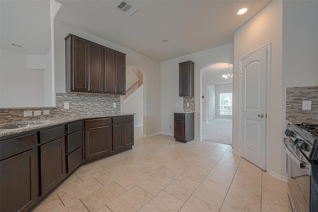 kitchen with decorative backsplash, dark brown cabinets, and range with electric cooktop