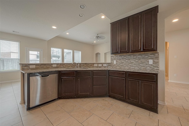 kitchen with stainless steel dishwasher, decorative backsplash, kitchen peninsula, and sink