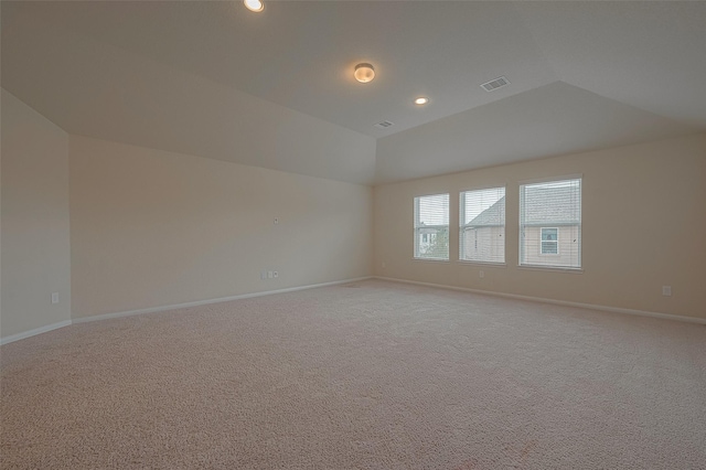 carpeted spare room featuring vaulted ceiling