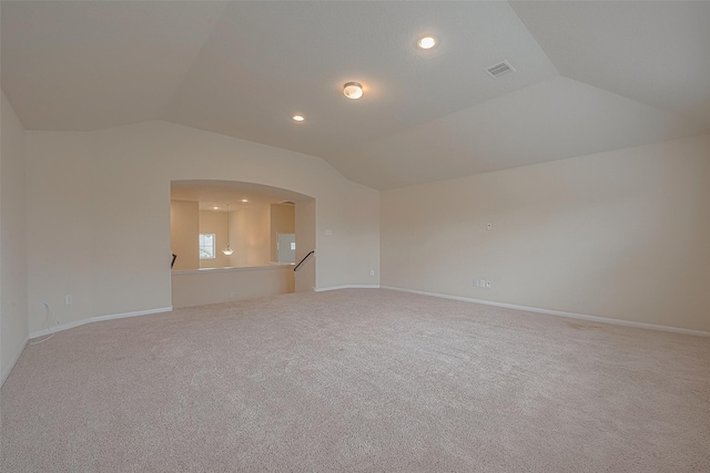 empty room with carpet flooring and vaulted ceiling