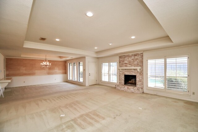 unfurnished living room featuring light carpet, a tray ceiling, and a brick fireplace