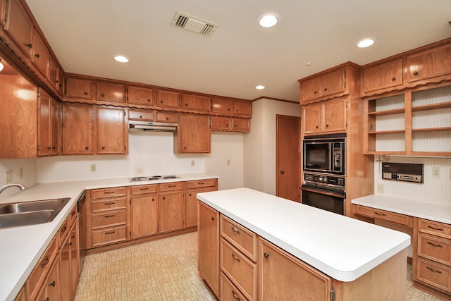 kitchen featuring sink, a kitchen island, black appliances, and ornamental molding