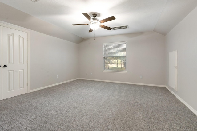 carpeted spare room with ceiling fan and vaulted ceiling