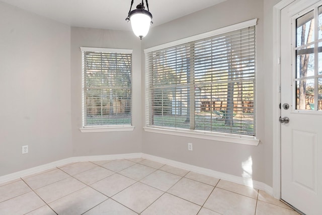 unfurnished dining area with light tile patterned flooring and a healthy amount of sunlight