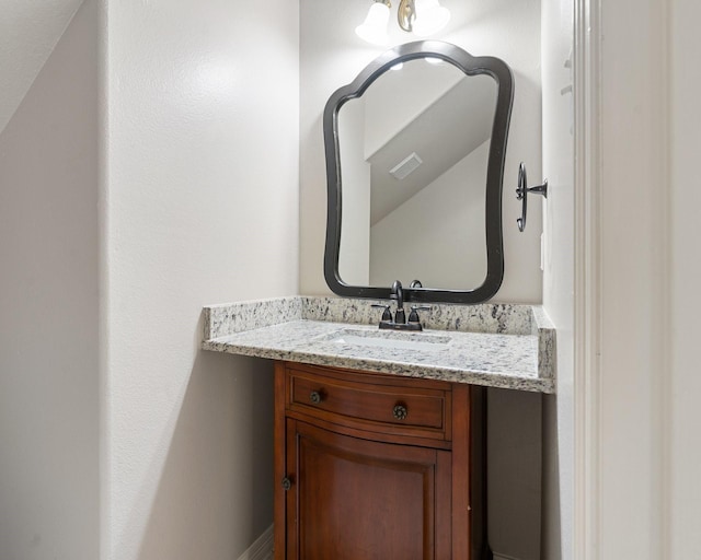 bathroom featuring vaulted ceiling and vanity