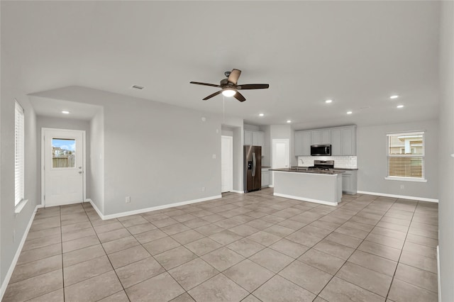 unfurnished living room with ceiling fan and light tile patterned floors