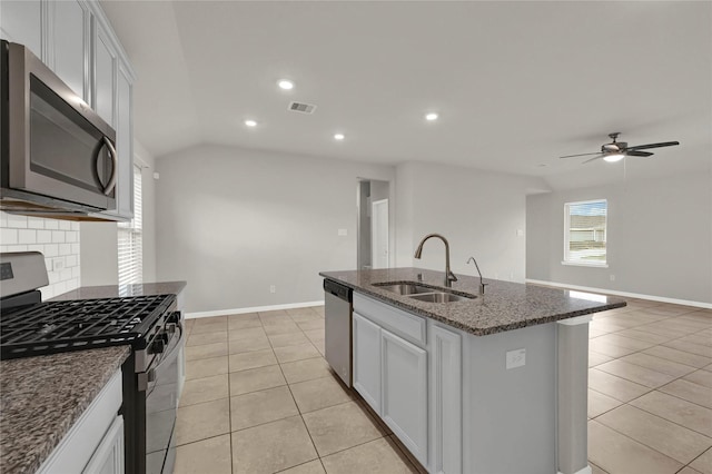 kitchen with appliances with stainless steel finishes, an island with sink, light tile patterned floors, and sink