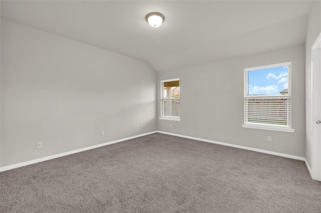 spare room with carpet flooring and vaulted ceiling