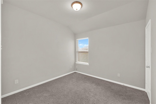 carpeted spare room featuring lofted ceiling