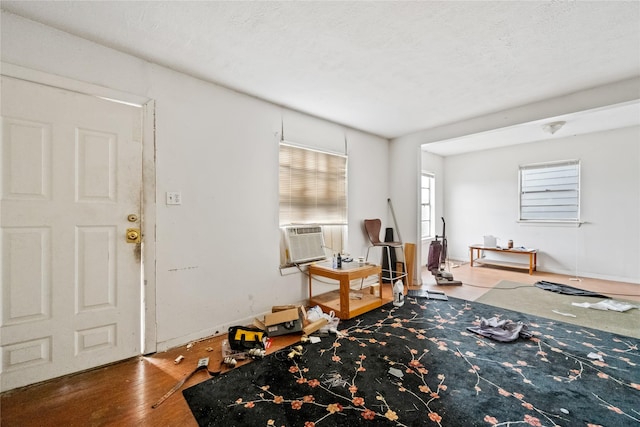 foyer entrance with a textured ceiling, cooling unit, and hardwood / wood-style floors