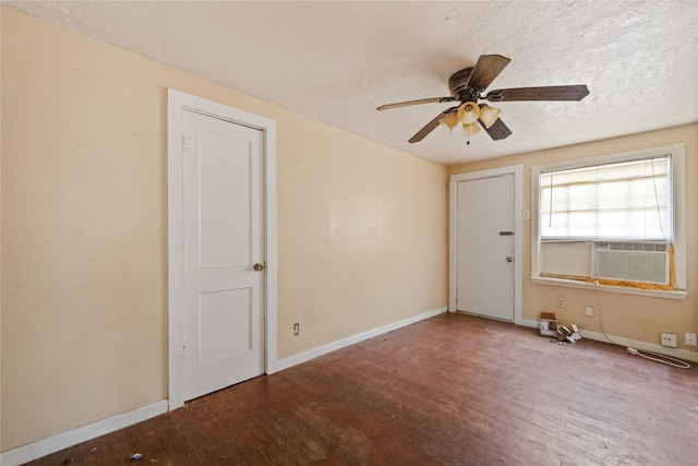 empty room featuring ceiling fan, hardwood / wood-style floors, a textured ceiling, and cooling unit