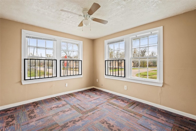 spare room with ceiling fan, a healthy amount of sunlight, and a textured ceiling